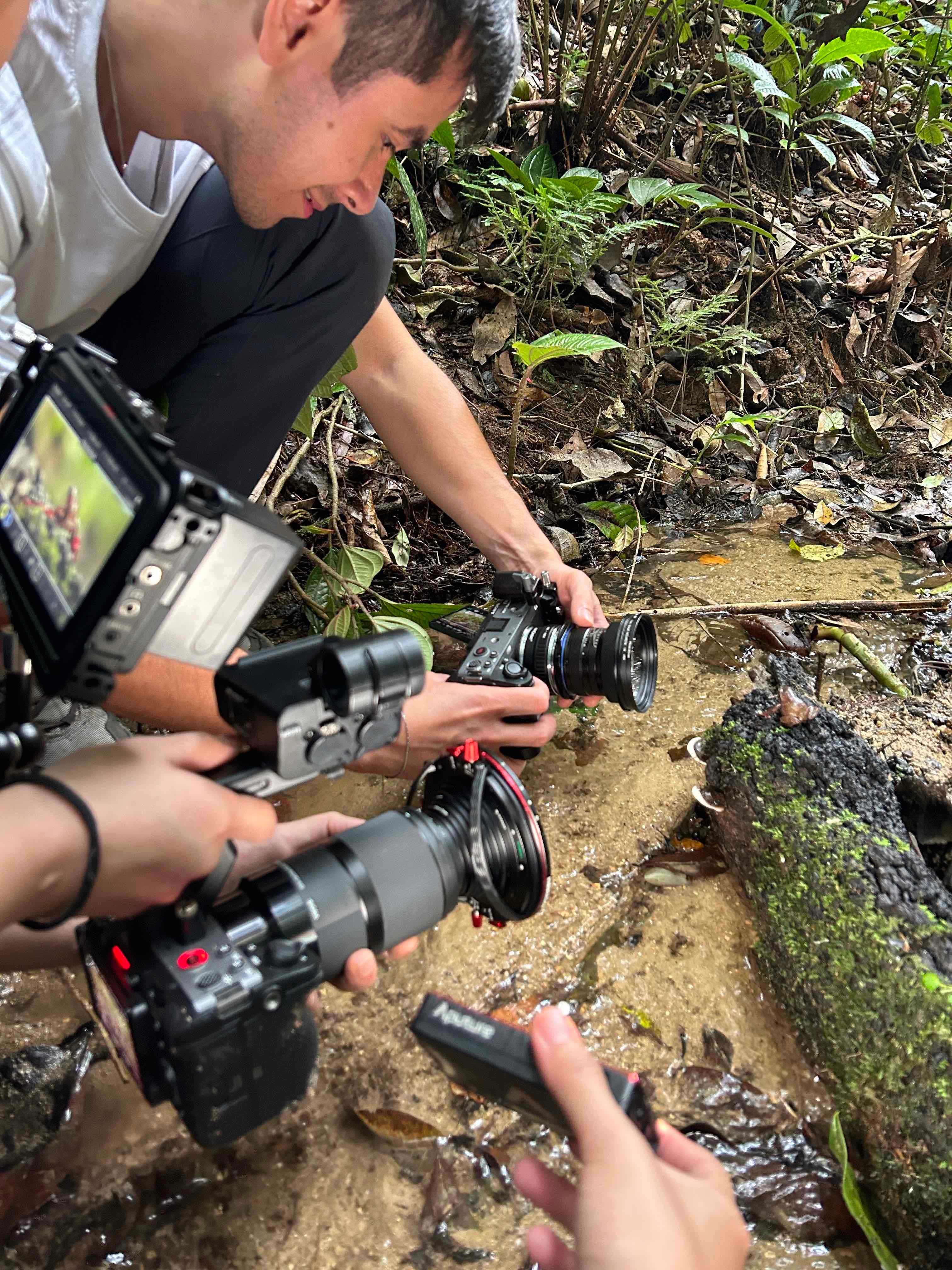 Myles Storey using a camera to photograph a frog